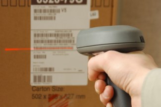 Hand holding scanner to shipping box label